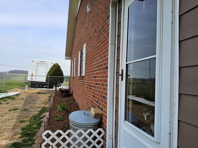 view of property exterior with brick siding and fence