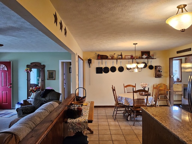 dining space featuring a textured ceiling, a notable chandelier, and light tile patterned floors