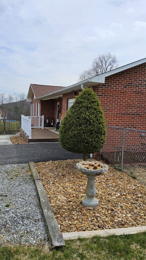 view of home's exterior featuring brick siding and a deck