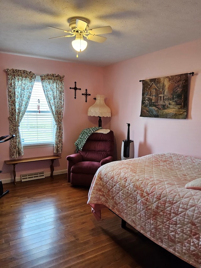 bedroom featuring hardwood / wood-style floors, baseboards, a textured ceiling, ceiling fan, and visible vents