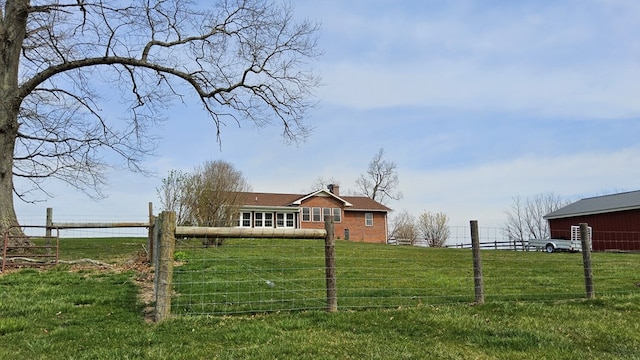 view of yard with fence and a rural view
