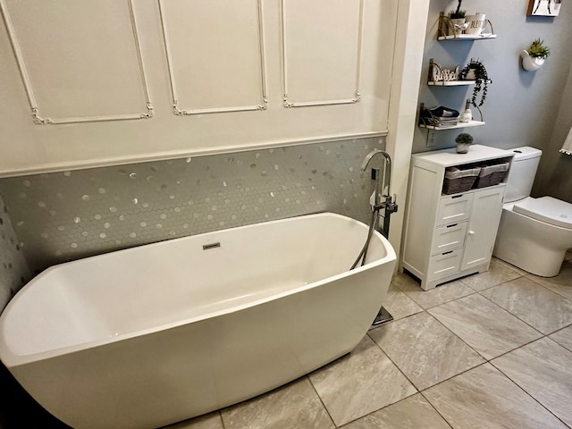 full bathroom with a freestanding tub and toilet