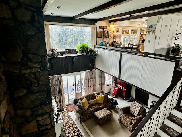 living room featuring a ceiling fan and beam ceiling