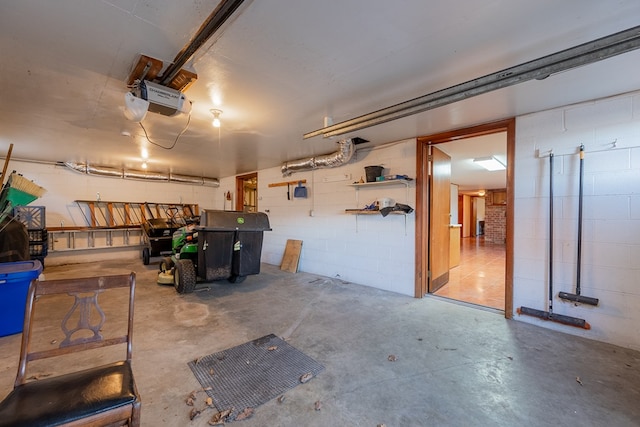 garage featuring concrete block wall and a garage door opener