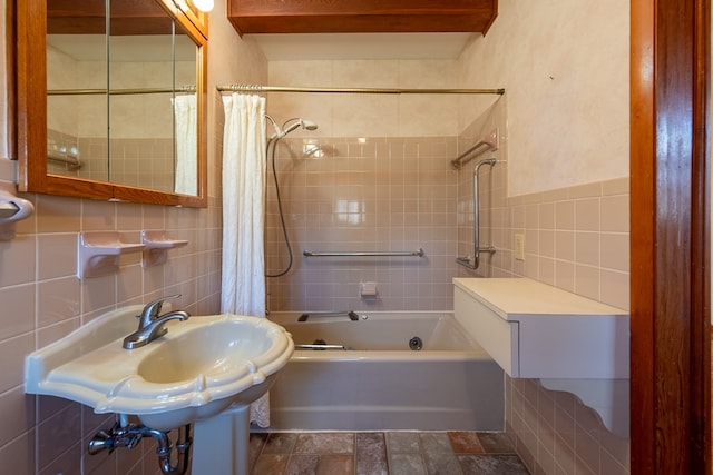 bathroom featuring a sink, tile walls, and shower / bath combination with curtain