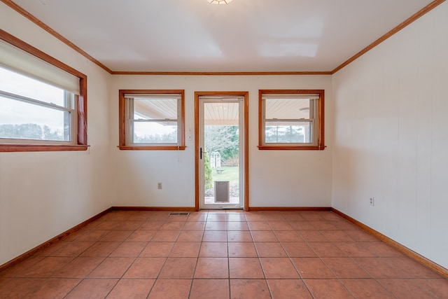 unfurnished room with light tile patterned floors, visible vents, baseboards, and ornamental molding