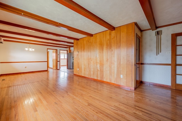 spare room with beamed ceiling, hardwood / wood-style flooring, wallpapered walls, baseboards, and a chandelier