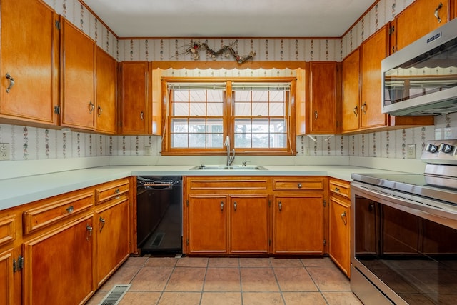 kitchen featuring wallpapered walls, a sink, brown cabinets, and stainless steel appliances