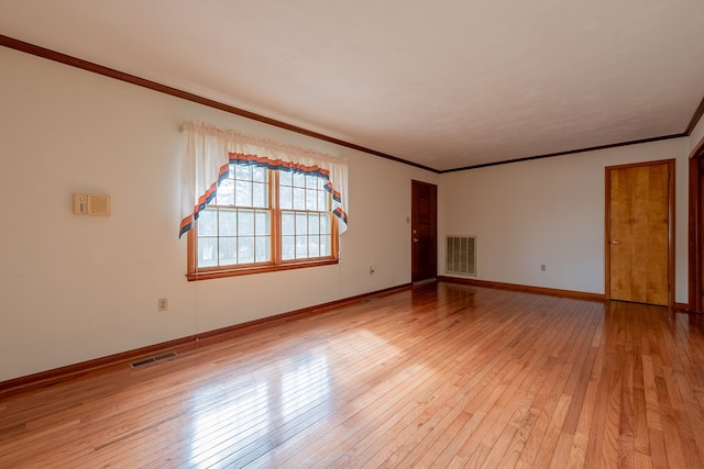 spare room with visible vents, light wood-style flooring, and crown molding