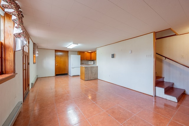 unfurnished living room featuring light tile patterned floors, a baseboard radiator, and stairs