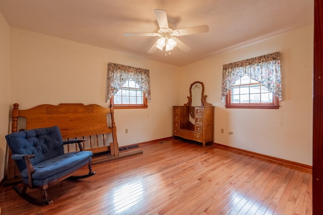 sitting room with light wood-type flooring, plenty of natural light, and baseboards