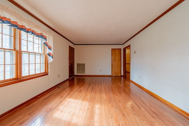 unfurnished room with light wood finished floors, visible vents, baseboards, and ornamental molding