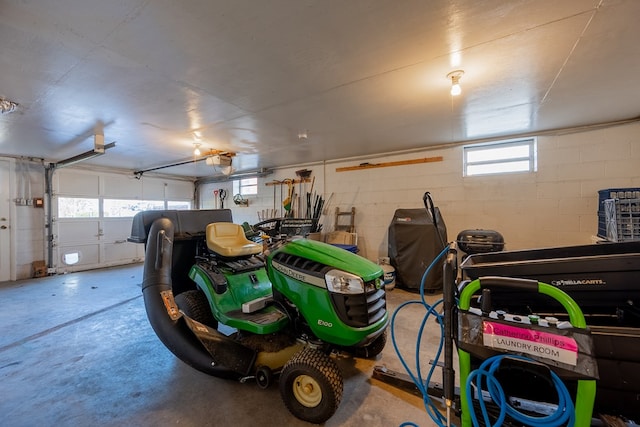 garage featuring concrete block wall and a garage door opener