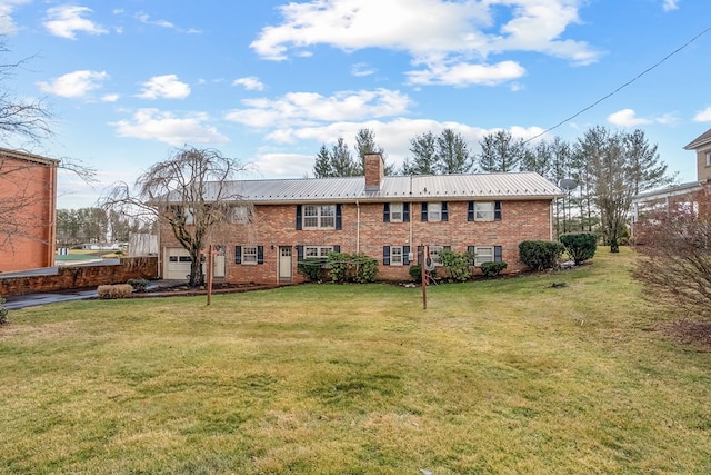 back of house featuring a chimney, metal roof, a yard, and brick siding