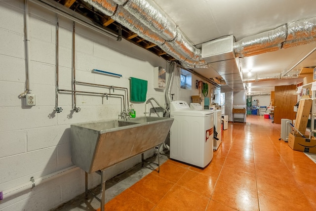 washroom with a sink, laundry area, and washing machine and clothes dryer