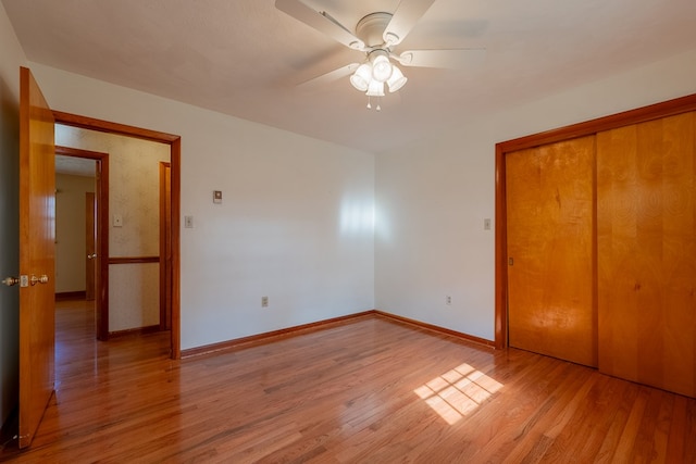 unfurnished bedroom featuring a closet, baseboards, light wood-style floors, and ceiling fan