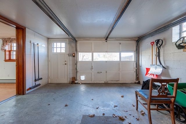 garage with baseboard heating and concrete block wall