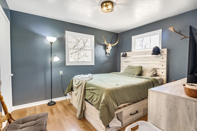 bedroom with light wood-style flooring and baseboards