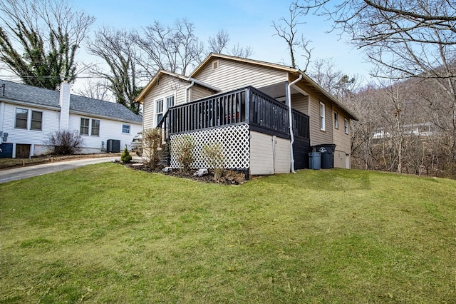 exterior space featuring a front yard, cooling unit, and driveway