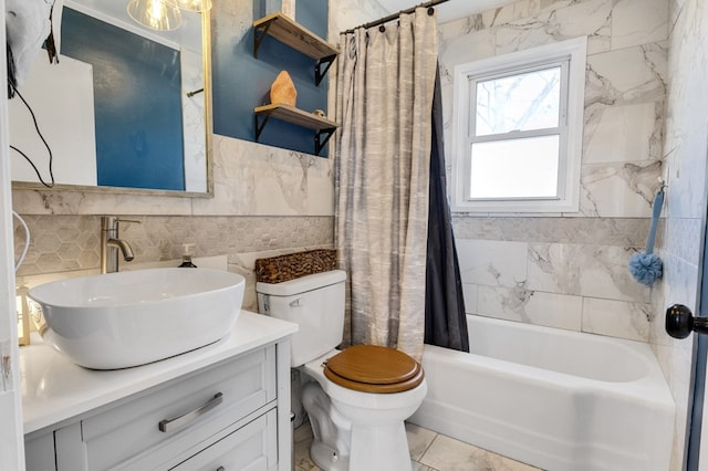 full bath with shower / tub combo, toilet, tile walls, and vanity