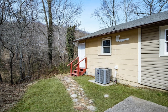 view of yard featuring entry steps and central AC