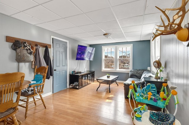 playroom with a drop ceiling, baseboards, and wood finished floors