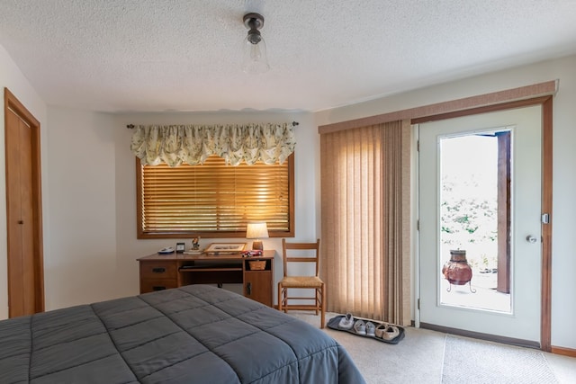 carpeted bedroom featuring access to outside and a textured ceiling