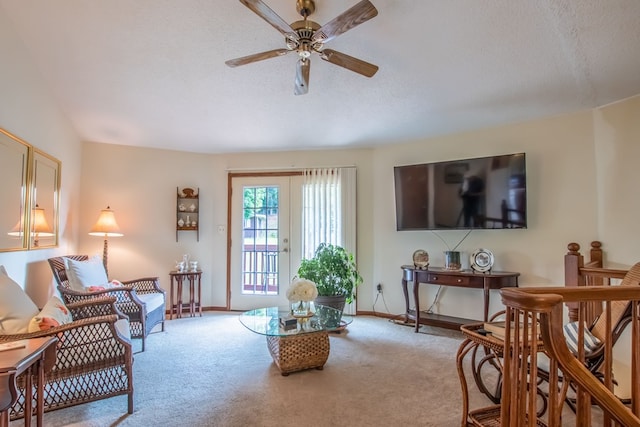 carpeted living room with ceiling fan and a textured ceiling