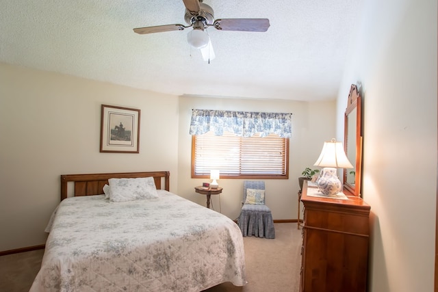 bedroom with a textured ceiling, carpet floors, and ceiling fan