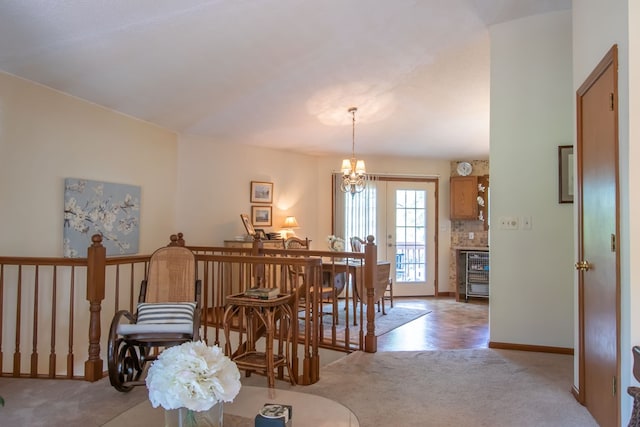 carpeted dining space featuring beverage cooler and a notable chandelier