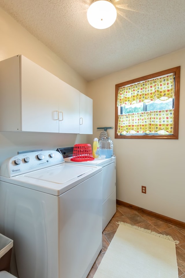 laundry area with cabinets, separate washer and dryer, light tile patterned floors, and a textured ceiling