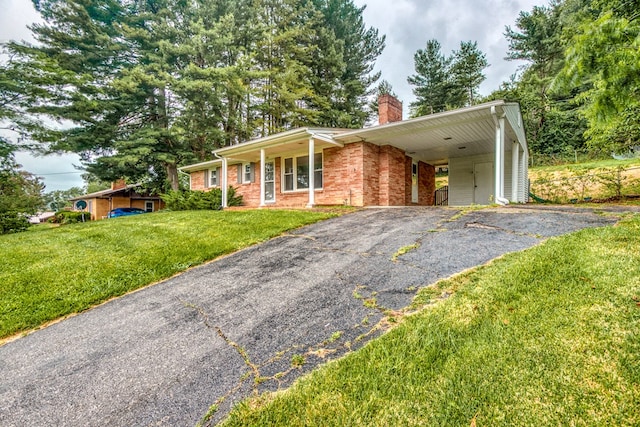 583 Fowler St, Marion, VA 24354 - ranch-style home featuring driveway, a chimney, a front lawn, a carport, and brick siding
