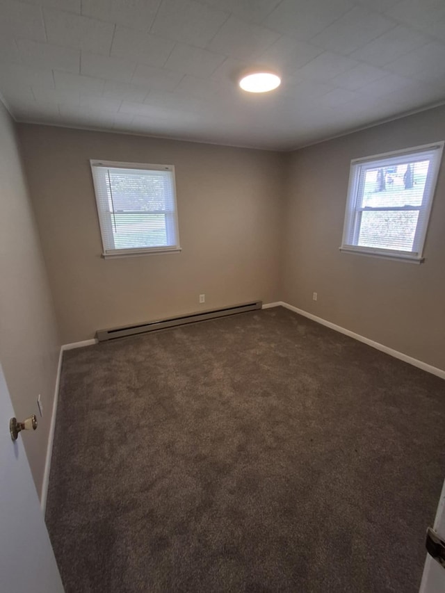 unfurnished room with a healthy amount of sunlight, baseboards, a baseboard radiator, and dark carpet