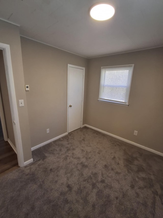 empty room featuring baseboards and carpet flooring