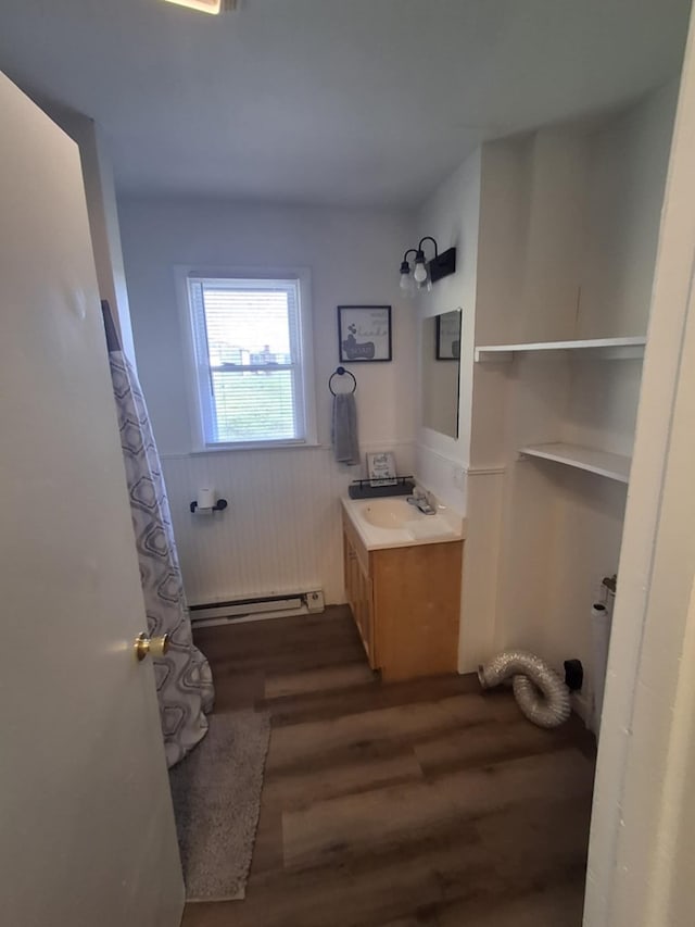 bathroom with vanity, a baseboard heating unit, and wood finished floors