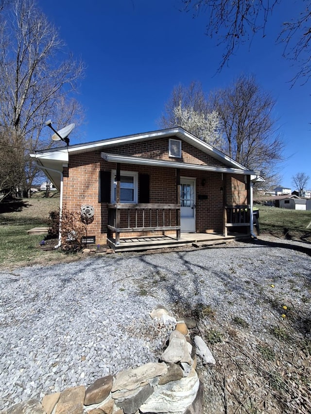 bungalow-style house featuring a porch and brick siding