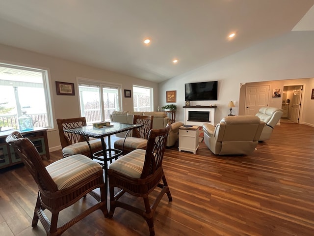 dining area with a fireplace, dark wood finished floors, recessed lighting, baseboards, and vaulted ceiling