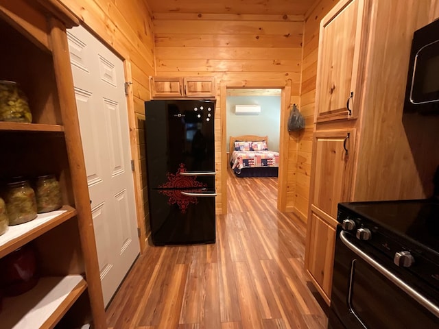 interior space with wood walls, light wood finished floors, and black appliances