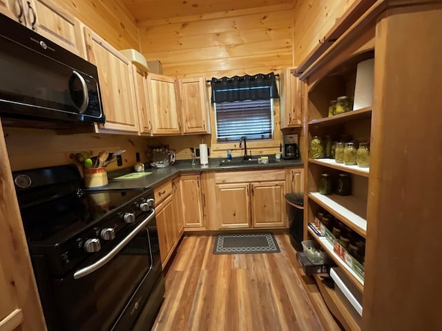 kitchen featuring black microwave, a sink, light brown cabinetry, and range with electric cooktop