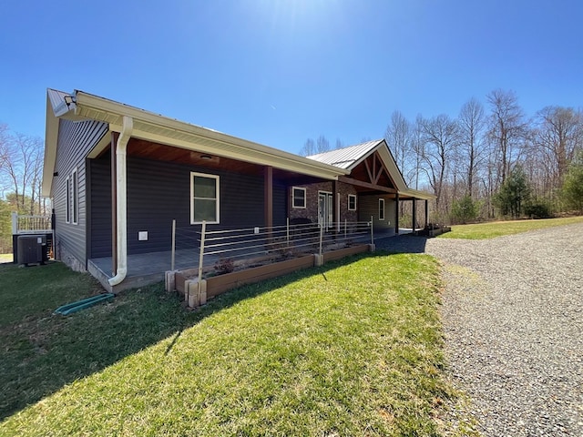 single story home with central air condition unit, a front yard, and metal roof
