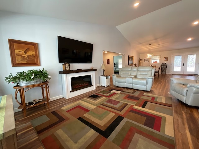 living room with a glass covered fireplace, wood finished floors, baseboards, recessed lighting, and vaulted ceiling