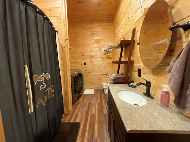 bathroom featuring vanity, wood walls, and wood finished floors