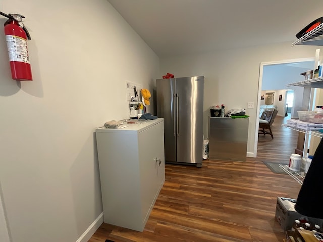 hall featuring baseboards and dark wood-type flooring