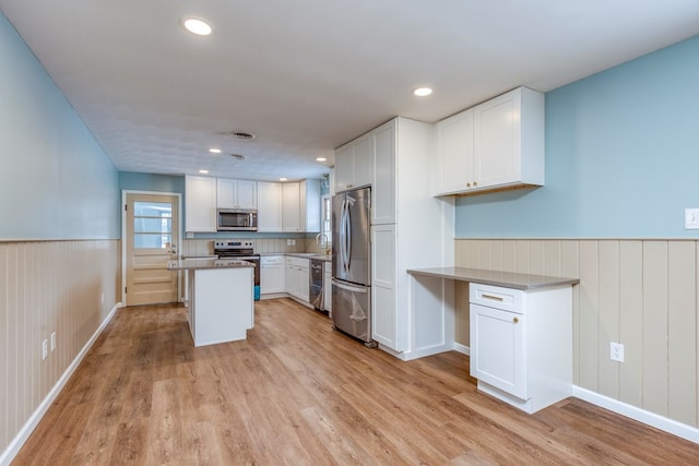867 NE Wayne Ave, Abingdon, VA 24210 - kitchen with appliances with stainless steel finishes, wainscoting, light wood-type flooring, white cabinets, and recessed lighting