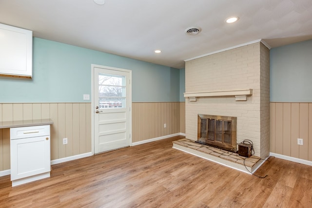 867 NE Wayne Ave, Abingdon, VA 24210 - unfurnished living room featuring wainscoting, light wood finished floors, a brick fireplace, and recessed lighting