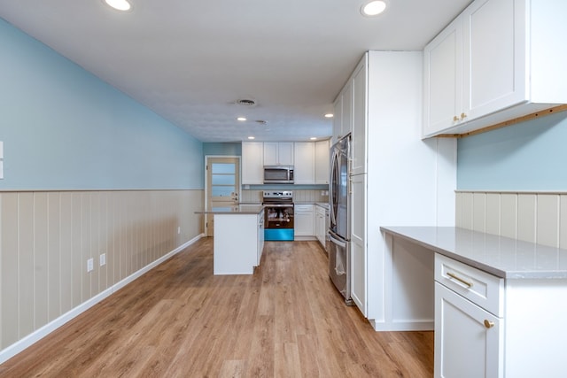 867 NE Wayne Ave, Abingdon, VA 24210 - kitchen featuring stainless steel appliances, light wood-type flooring, white cabinetry, a wainscoted wall, and recessed lighting