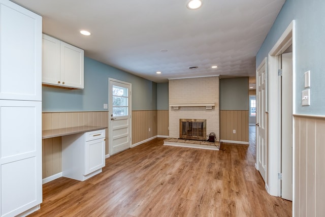 867 NE Wayne Ave, Abingdon, VA 24210 - unfurnished living room featuring wainscoting, light wood finished floors, a brick fireplace, and recessed lighting