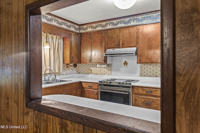 3608 Old Brandon Rd, Pearl, MS 39208 - kitchen featuring under cabinet range hood, range with electric stovetop, a sink, and brown cabinets