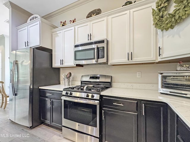14 Le Petit Cv, Long Beach, MS 39560 - kitchen featuring stainless steel appliances, white cabinetry, light stone counters, dark cabinetry, and light wood finished floors