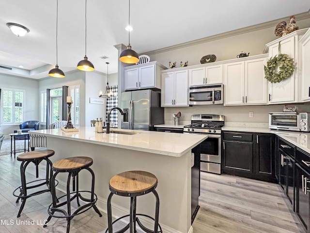 14 Le Petit Cv, Long Beach, MS 39560 - kitchen featuring appliances with stainless steel finishes, a kitchen bar, dark cabinets, white cabinetry, and ornamental molding